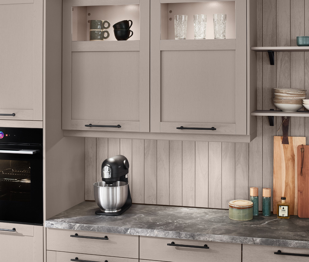 Ett shaker kök i färgen macchiato med marmorbänkskiva och svarta detaljer